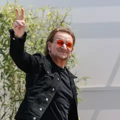 Bono con occhiali arancioni fa il segno di vittoria, forse un anticipo del nuovo u2 new album.