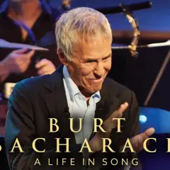 Burt Bacharach, leggendario compositore, sorride sul palco, celebrando le sue indimenticabili canzoni.