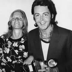 Paul McCartney sorride con una donna, entrambi tengono premi. Potrebbe essere un momento legato a un album di Paul McCartney.