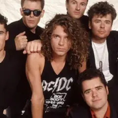 I membri degli INXS posano insieme, un gruppo di sei uomini con stili diversi, pronti a conquistare il mondo con la loro musica.