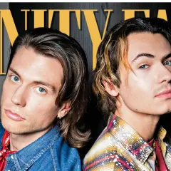 Due giovani uomini, uno con camicia di jeans e bandana rossa, l'altro con camicia a quadri, posano per Vanity Fair. Chissà quale sarà la loro prossima canzone, dove e quando la ascolteremo.