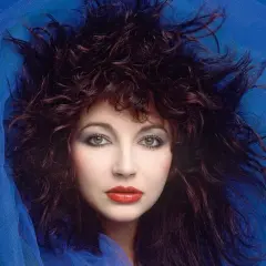 Ritratto di Kate Bush con capelli scuri e fluenti, occhi verdi penetranti e labbra rosse, avvolta in un velo blu. Un'icona delle canzoni di Kate Bush.