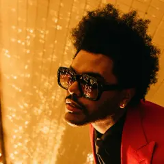The Weeknd, con occhiali oversize e giacca rossa, pronto per le avventure after hours.