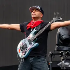 Tom Morello, chitarrista famoso americano, con la sua iconica chitarra "Arm the Homeless" sul palco.