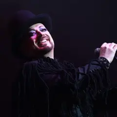 Boy George, icona dei Culture Club, canta con trucco audace e cappello a cilindro.