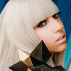 Lady Gaga con i suoi iconici capelli biondi e un look audace, ricorda la sua prima canzone.