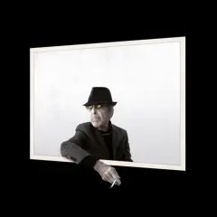 Uomo con cappello e occhiali da sole, sigaretta in mano, sembra volere un'atmosfera più scura.