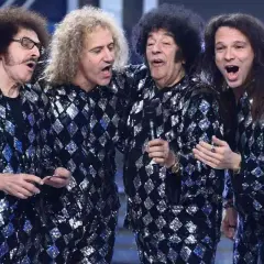 I cugini di campagna originali, con le loro iconiche giacche scintillanti, cantano sul palco con entusiasmo.