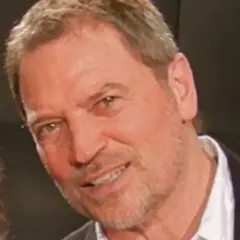 Primo piano di Franco Simone, artista noto per le sue canzoni. Sorride con un'espressione cordiale.