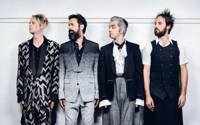 I membri dei Bluvertigo posano in abiti eleganti e audaci, pronti per un nuovo capitolo musicale.