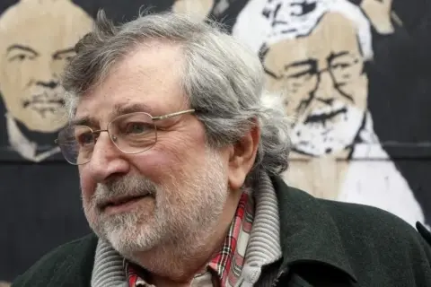 Ritratto di Francesco Guccini, con alle spalle un murale che ricorda "L'Avvelenata".