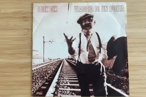 Copertina disco "Viaggio di un poeta" I Dik Dik: un uomo con cappello e barba, in piedi sui binari, sembra narrare storie.