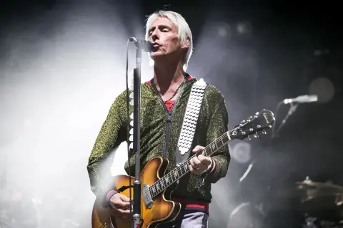 Paul Weller, con la sua chitarra, canta sul palco, un'icona delle canzoni di Paul Weller.