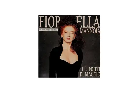 Fiorella Mannoia, con il suo look iconico, interpreta "Le notti di maggio" in un'immagine che evoca la magia del Festival di Sanremo.