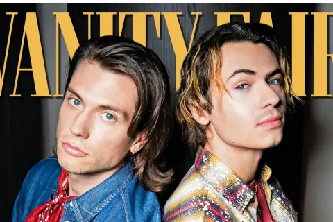 Due giovani uomini, uno con camicia di jeans e bandana rossa, l'altro con camicia a quadri, posano per Vanity Fair. Chissà quale sarà la loro prossima canzone, dove e quando la ascolteremo.