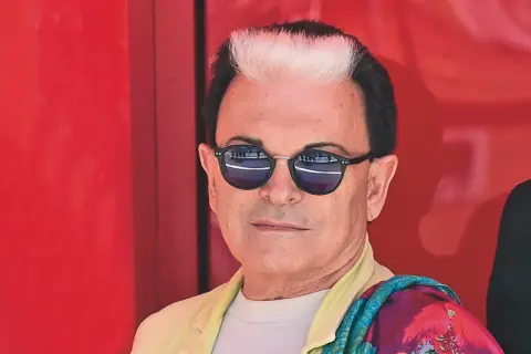 Cristiano Malgioglio, con i suoi capelli bicolore e occhiali da sole, pronto a raccontare le sue canzoni scritte.
