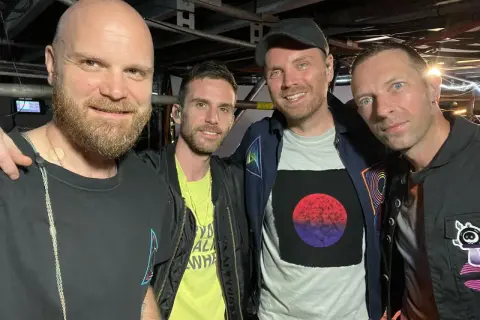 I membri dei Coldplay, Will Champion, Guy Berryman, Jonny Buckland e Chris Martin, sorridono in un selfie dietro le quinte.