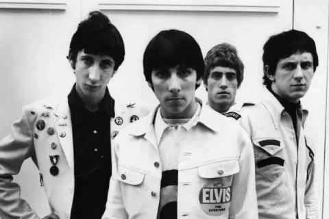 I quattro membri di the who cantante posano per una foto. Il cantante Roger Daltrey è in primo piano, con Pete Townshend, John Entwistle e Keith Moon alle sue spalle.