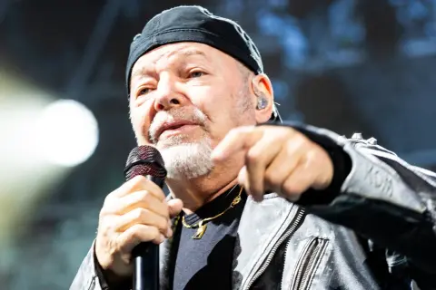 Gerardina trovato, ma non ho più la mia città. Un uomo con berretto nero e giacca di pelle canta al microfono, puntando il dito verso l'esterno.