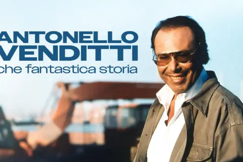 Antonello Venditti sorride, con occhiali da sole e giacca, in un'immagine che evoca un ricordo di settembre e una fantastica storia.