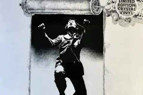 Black and white illustration of a person unrolling a scroll, with "Limited Edition Crystal Vinyl Records" text.