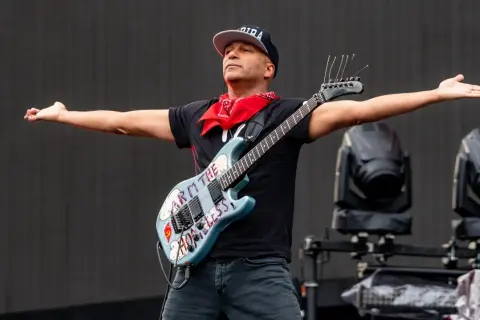 Tom Morello, chitarrista famoso americano, con la sua iconica chitarra "Arm the Homeless" sul palco.