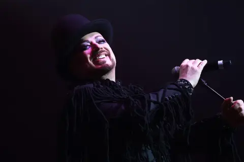 Boy George, icona dei Culture Club, canta con trucco audace e cappello a cilindro.