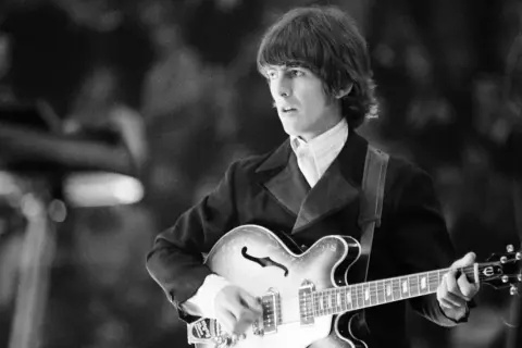 George Harrison, con la sua chitarra, crea le melodie indimenticabili delle sue canzoni.