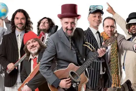 I membri della Bandabardò, con strumenti e cappelli stravaganti, pronti a suonare le loro canzoni.