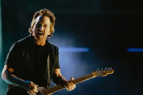 Eddie Vedder con la sua chitarra sul palco, un momento intenso della sua band.