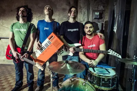 Quattro ragazzi con magliette a tema musicale, pronti a fare rock. Un gruppo di giovani artisti italiani.