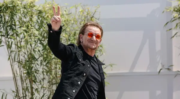 Bono con occhiali arancioni fa il segno di vittoria, forse un anticipo del nuovo u2 new album.