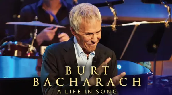 Burt Bacharach, leggendario compositore, sorride sul palco, celebrando le sue indimenticabili canzoni.