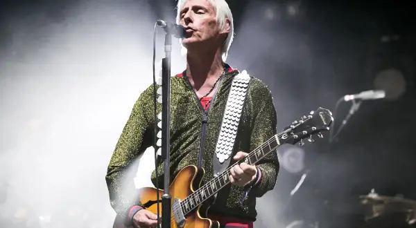 Paul Weller, con la sua chitarra, canta sul palco, un'icona delle canzoni di Paul Weller.