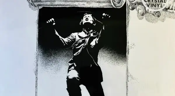 Black and white illustration of a person unrolling a scroll, with "Limited Edition Crystal Vinyl Records" text.
