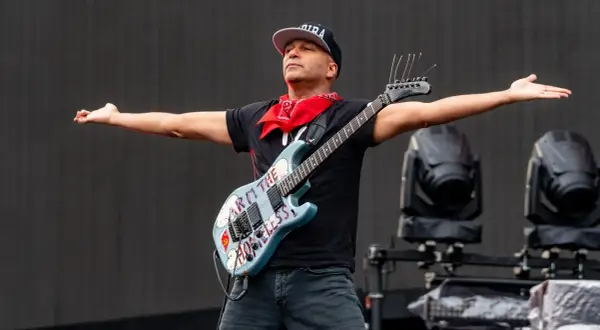 Tom Morello, chitarrista famoso americano, con la sua iconica chitarra "Arm the Homeless" sul palco.