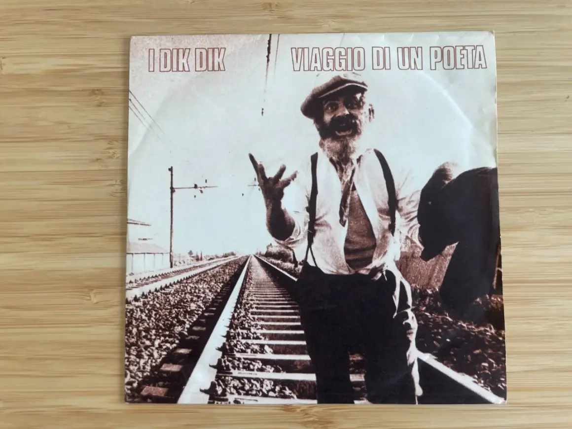 Copertina disco "Viaggio di un poeta" I Dik Dik: un uomo con cappello e barba, in piedi sui binari, sembra narrare storie.