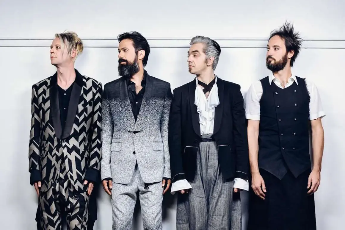 I membri dei Bluvertigo posano in abiti eleganti e audaci, pronti per un nuovo capitolo musicale.