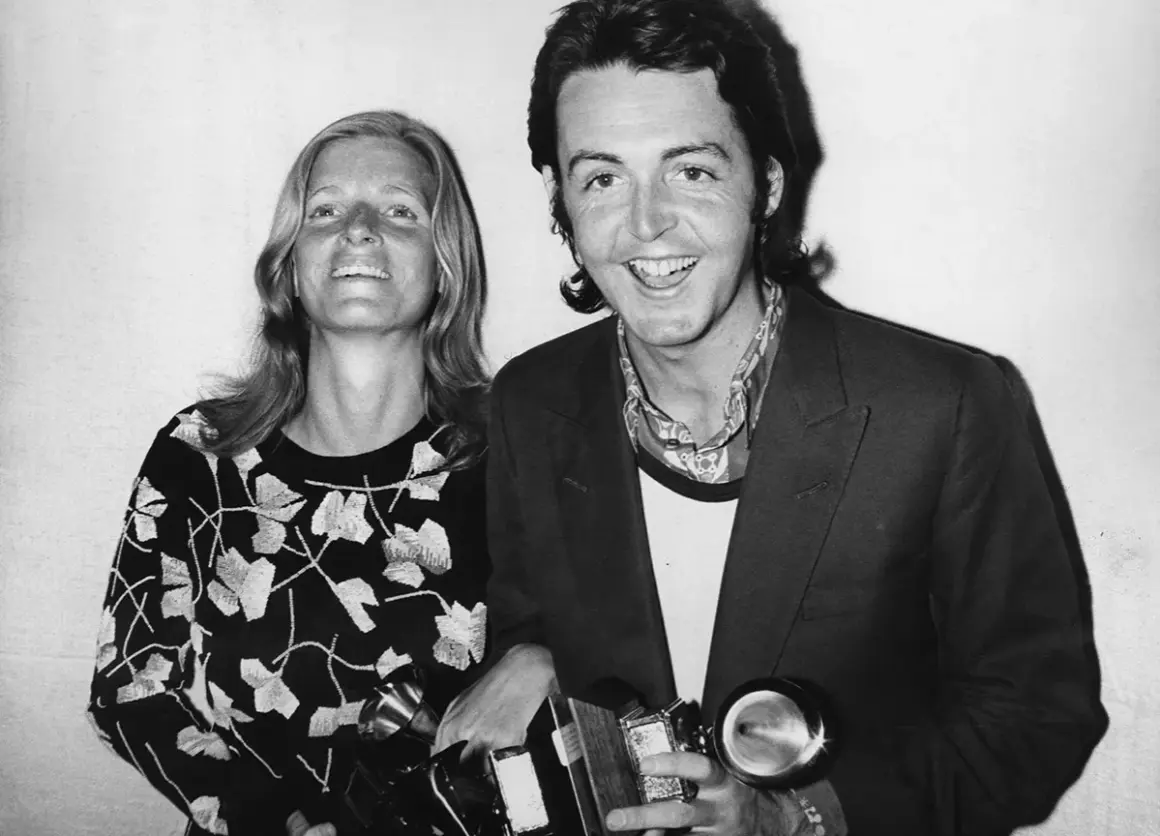 Paul McCartney sorride con una donna, entrambi tengono premi. Potrebbe essere un momento legato a un album di Paul McCartney.