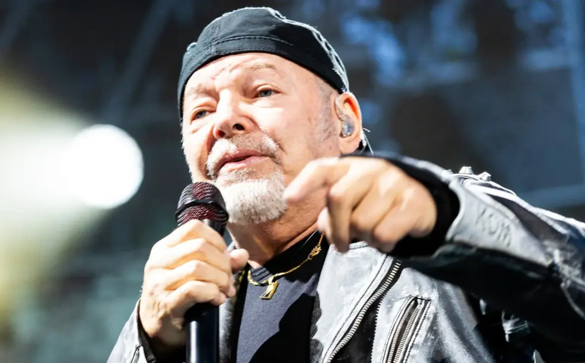 Gerardina trovato, ma non ho più la mia città. Un uomo con berretto nero e giacca di pelle canta al microfono, puntando il dito verso l'esterno.