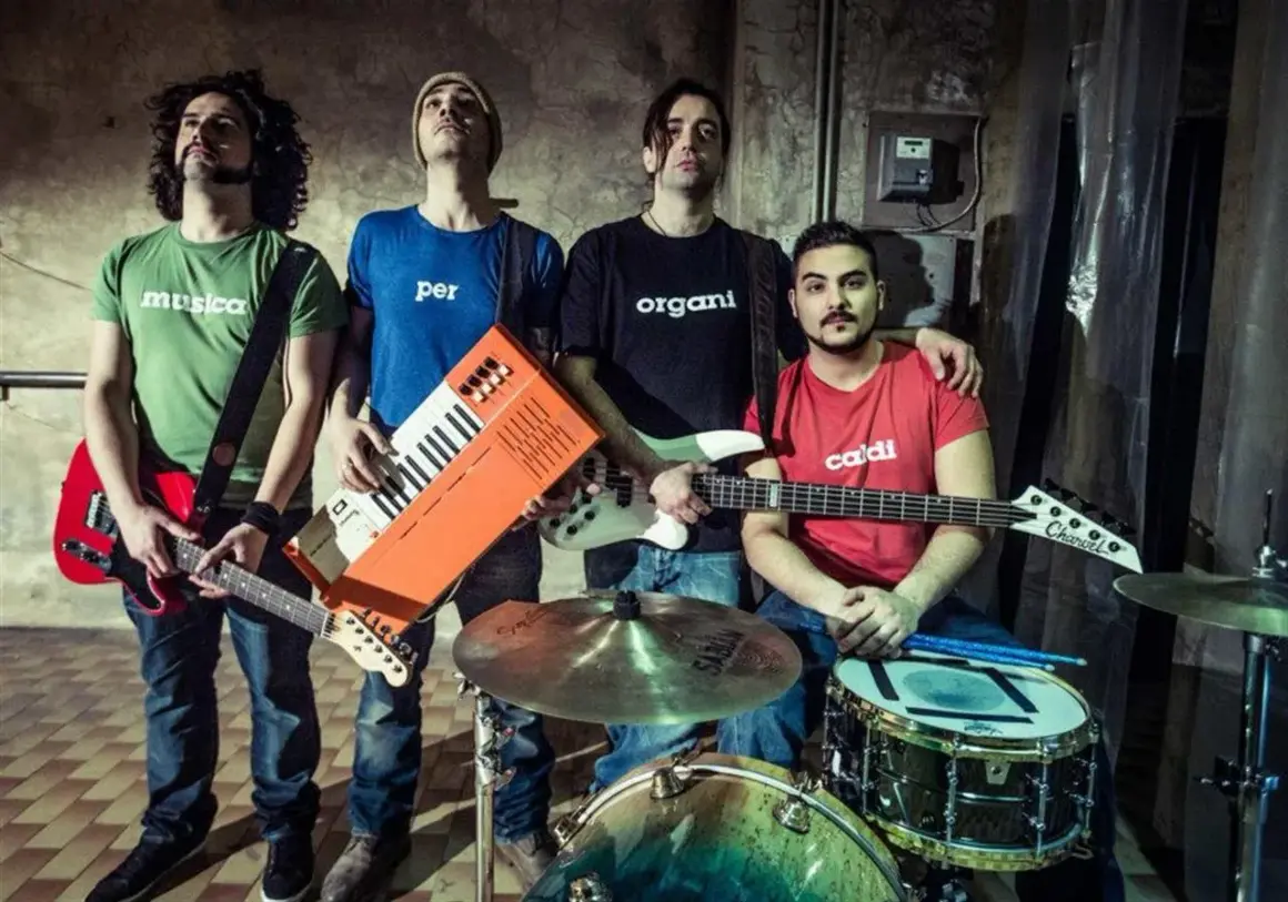 Quattro ragazzi con magliette a tema musicale, pronti a fare rock. Un gruppo di giovani artisti italiani.