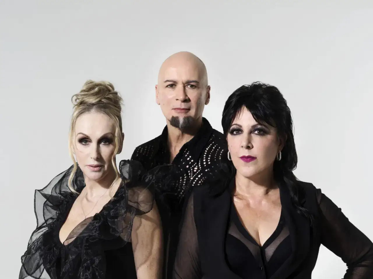 I membri di The Human League, Philip Oakey, Joanne Catherall e Susan Ann Sulley, posano in abiti scuri.