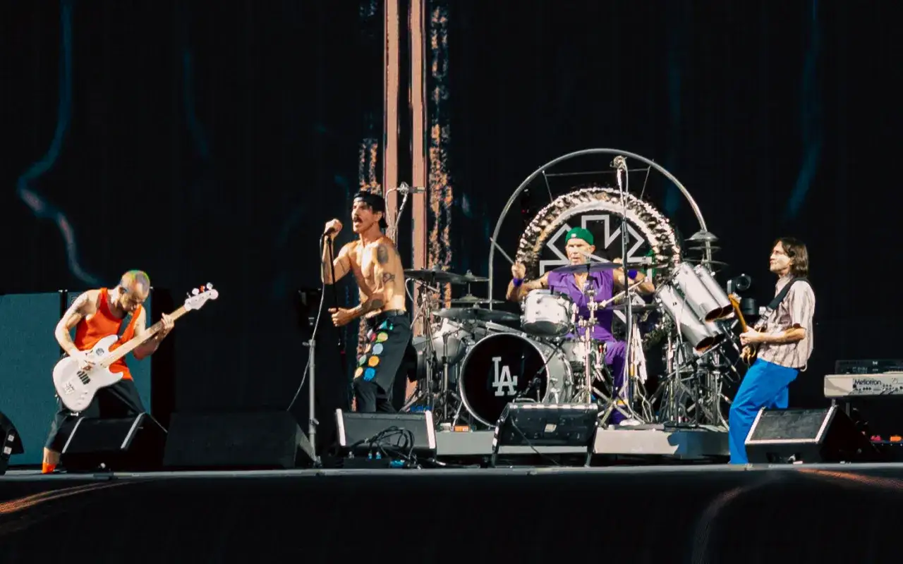Il chitarrista dei Red Hot Chili Peppers sul palco, con il cantante e il batterista.