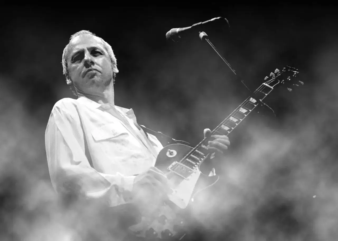 Chitarrista sul palco, avvolto dal fumo, con la sua Gibson. Un'icona tra i 100 migliori chitarristi secondo Guitar World.