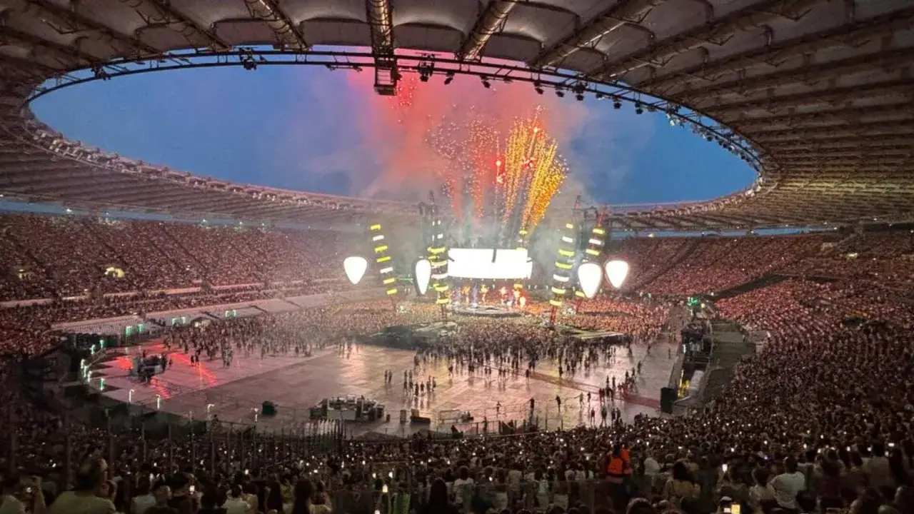 Concerto di Antonello Venditti a Roma, uno stadio gremito sotto un cielo stellato e fuochi d'artificio.