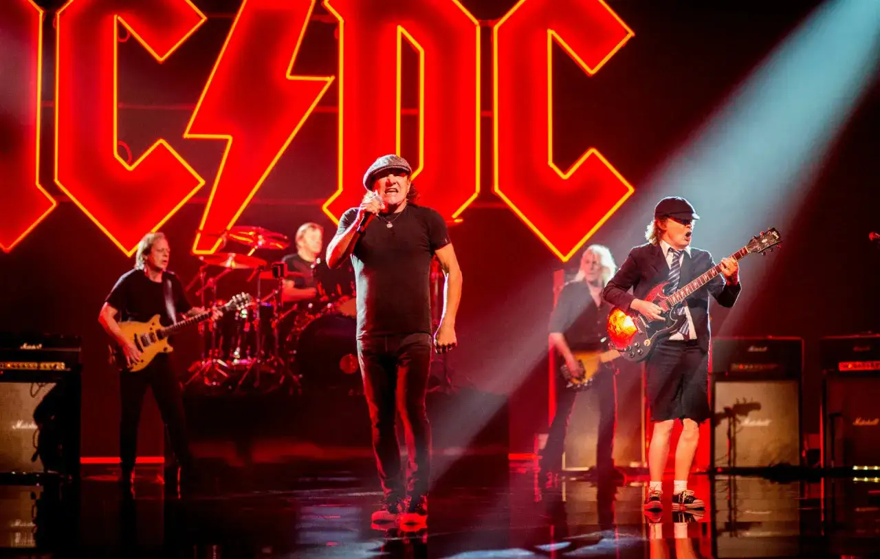 La band AC/DC sul palco, con il cantante Brian Johnson in primo piano e Angus Young alla chitarra.