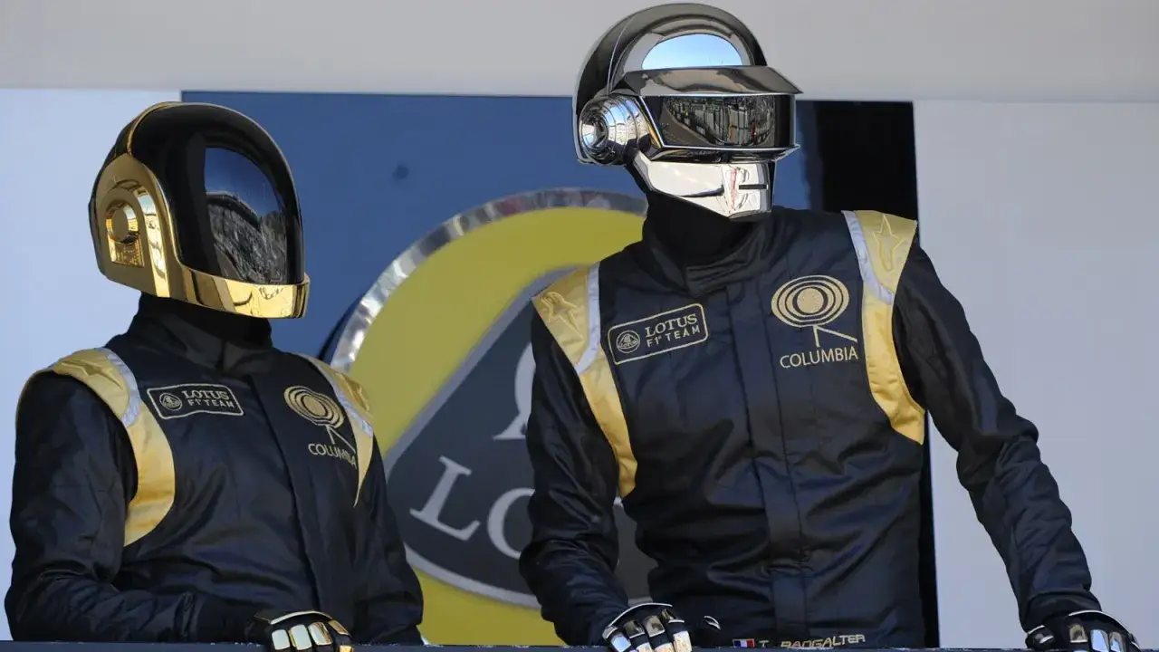I Daft Punk, duo iconico, indossano tute da gara nere e oro con caschi distintivi.