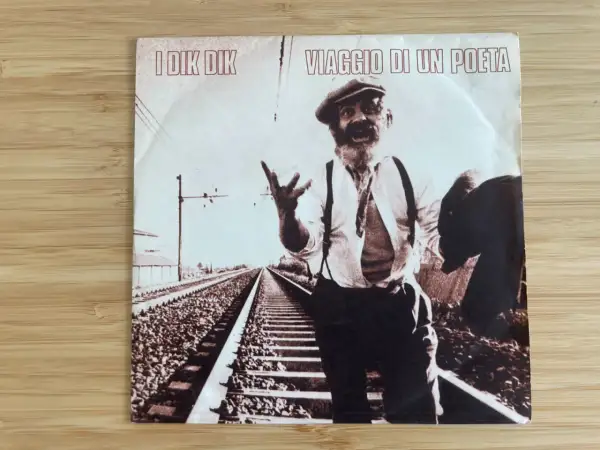 Copertina disco "Viaggio di un poeta" I Dik Dik: un uomo con cappello e barba, in piedi sui binari, sembra narrare storie.