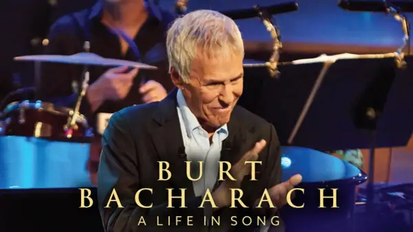Burt Bacharach, leggendario compositore, sorride sul palco, celebrando le sue indimenticabili canzoni.