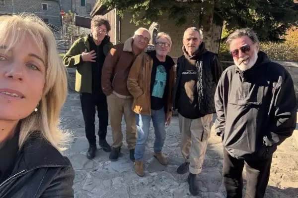 Un gruppo di musicisti del consorzio suonatori indipendenti posa all'aperto, con una donna in primo piano.